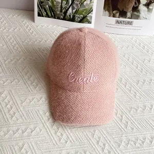 Dettaglio del cappello da baseball rosa in ciniglia con ricamo e morbida trama felpata