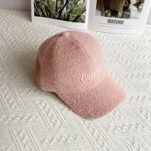 Dettaglio del cappello da baseball in ciniglia rosa con morbido tessuto e ricamo 'Create'