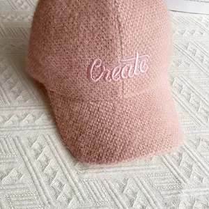 Dettaglio del cappellino rosa in ciniglia con ricamo a lettere Create in rilievo