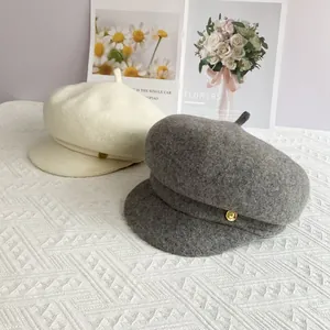Casquettes gavroche en laine beige et grise avec boutons dorés pour l'automne-hiver
