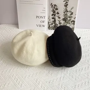 Close-up of wool beret hats with silver stud rivets on the brim and classic stem detail