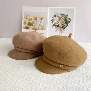 Vue détaillée de deux casquettes de marin en laine coloris camel et taupe avec détails dorés