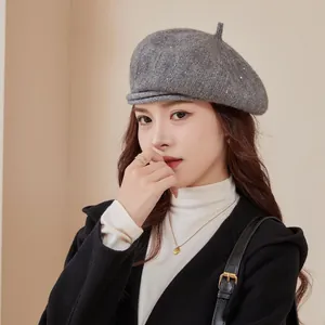 Detailed view of gray chenille knitted beret with subtle sequins on a female model