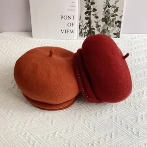 Wool beret hats in caramel and dark red with rivet details for autumn and winter
