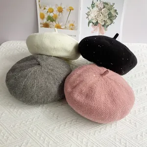 Detail of sequined chenille knit berets in cream, black, grey and pink colors