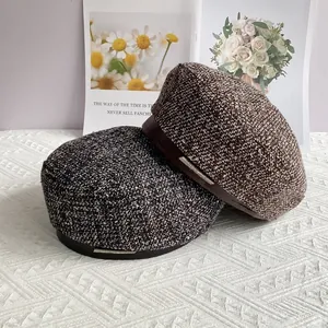Détails macro des casquettes en tweed avec bordure en similicuir et accents métalliques