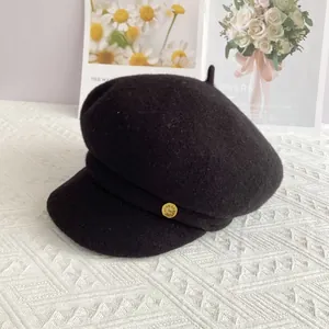 Vue détaillée d'une casquette de marin noire en laine avec un emblème en métal doré