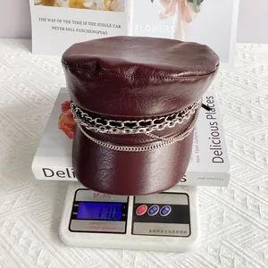 Close-up of lightweight burgundy PU leather baker boy hat weighing 170g on a digital scale