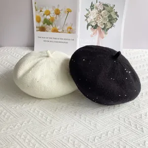Detail of chenille knit berets with sparkling sequins in white and black colors