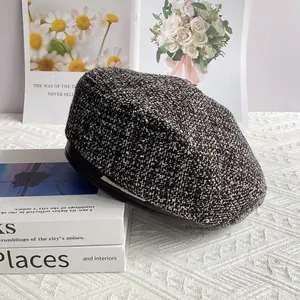 Détail du béret en tweed avec texture tissée noire et blanche et liseré argenté