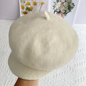 Détail d'une casquette gavroche en laine crème avec texture douce et couronne arrondie