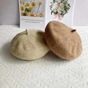 Sequin chenille knit berets in beige and brown displayed on a textured background