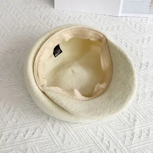 Détail de l'intérieur du béret en laine beige avec bandeau et étiquette 56-58cm