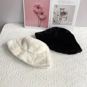 Close-up of plush faux mink fur bucket hats in black and white with stitched texture