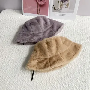 Detail of plush faux mink fur bucket hats with thick textured grid patterns in soft tones