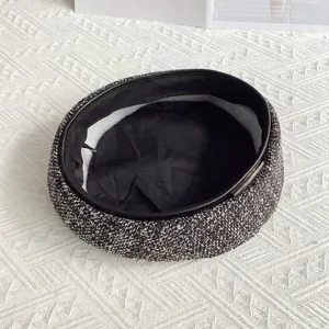 Détail de l'intérieur du béret en tweed avec doublure noire et bandeau en cuir