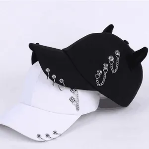 Dettaglio del cappello gothic con anelli d'argento, catene e corna di demone decor