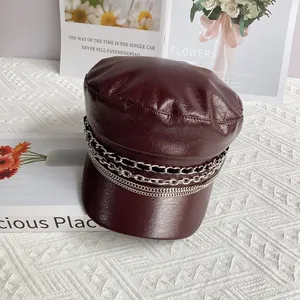 Close-up of burgundy PU leather baker boy hat featuring triple silver chain details