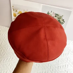 Detail shot of a dark red wool beret showing soft texture and neat stitching details