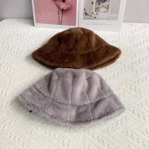 Detailed view of faux mink fur bucket hats in brown and purple with grid stitching