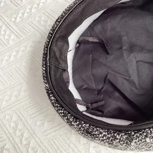 Vue détaillée du béret en tweed montrant la doublure noire et le lien de serrage