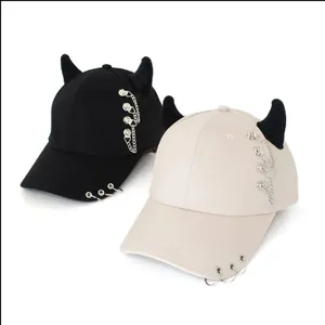 Dettaglio del cappello punk con corna da diavolo 3D e decorazioni con catene metalliche