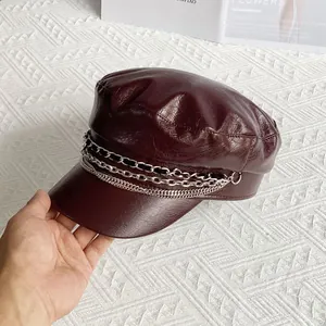 Detailed view of dark red PU leather newsboy cap with multi-layer metal chain accents