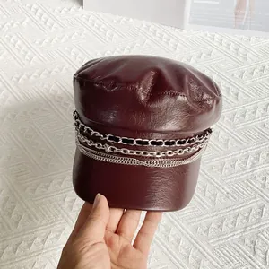 Detailed texture of burgundy PU leather baker boy hat with silver metal chain decor