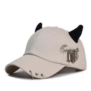 Berretto hip-hop beige con corna da diavolo nere e ciondoli punk in metallo sulla visiera