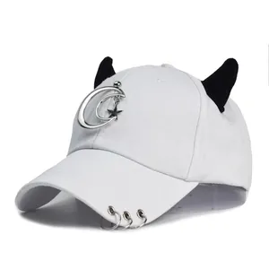 Dettaglio del cappellino da baseball in cotone bianco con corna e ciondoli argento
