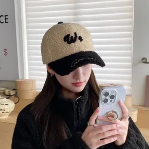 Detalle de gorra de béisbol de felpa caqui con bordado W negro y visera en contraste