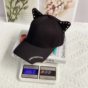 Close-up of punk cat ear baseball cap with silver rivets weighing 91g on a scale