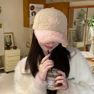 Detalle de letra W rosa bordada en gorra de béisbol de forro polar beige invierno