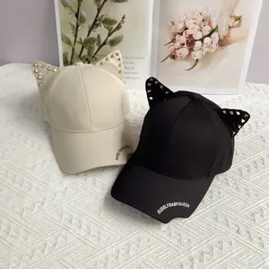 Close-up of punk style baseball caps with rivet cat ears and letter printed brims
