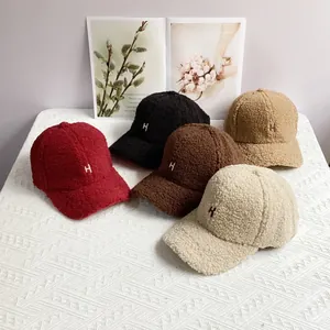 Close-up of five colorful sherpa fleece baseball hats with H embroidery in warm setting