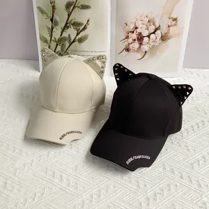 Studded cat ear punk baseball caps in black and cream beige with silver rivet details