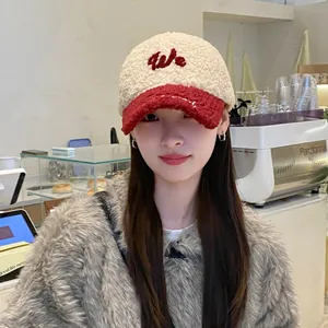 Primer plano de gorra de béisbol de borreguito bicolor con detalle de bordado 'We'