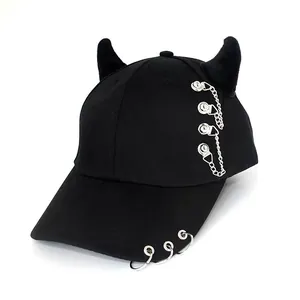 Detail of black punk baseball cap with plush horns, metal chains and brim rings