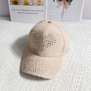 Detailed view of apricot knitted baseball cap featuring sparkling rhinestone heart design