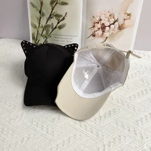 Punk style baseball cap with cat ears and silver rivets in black and beige colors