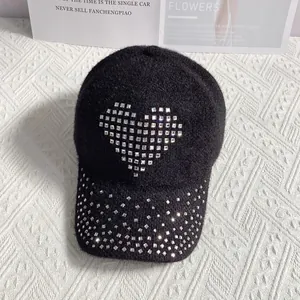 Close-up of heart-shaped rhinestone detailing on a black textured wool baseball cap