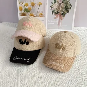 Detalle de gorras de béisbol de forro polar sherpa con bordado de letras WE