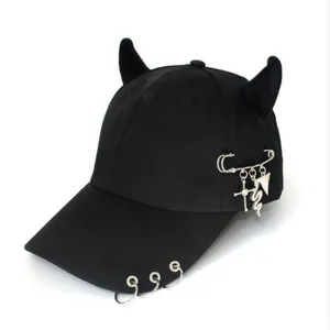Dettaglio cappello punk con corna da diavolo, anelli d'argento e pendenti gotici