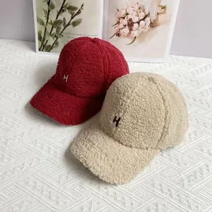 Flat lay of soft lamb wool baseball caps in red and beige with H letter embroidery