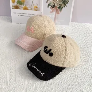 Detalle de gorras de béisbol bicolor en forro polar teddy con letras bordadas y suaves