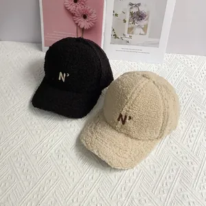 Pair of plush lamb wool baseball caps in black and cream white with N' letter embroidery