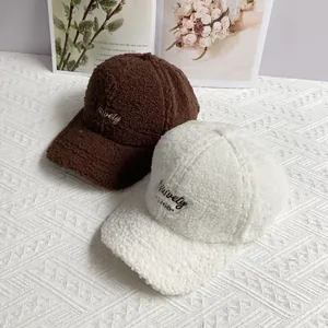 Close-up of thick sherpa fleece texture and letter embroidery on baseball caps