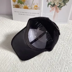 Detail view of black rabbit hair blend baseball cap with silver ring and soft plush texture