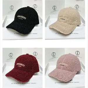 Detail view of four warm fleece baseball caps in black, beige, burgundy and pink