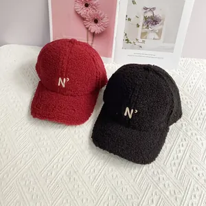 Detail of red and black lamb wool baseball caps with embroidered N' letter logo texture